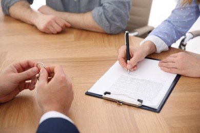 Photo of Real estate agent working with clients in office, closeup