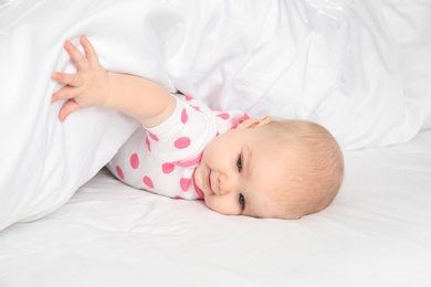 Photo of Cute baby girl in bed at home. Bedtime schedule