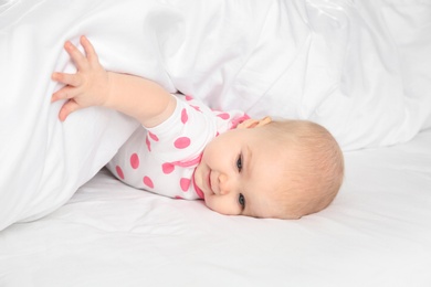 Cute baby girl in bed at home. Bedtime schedule