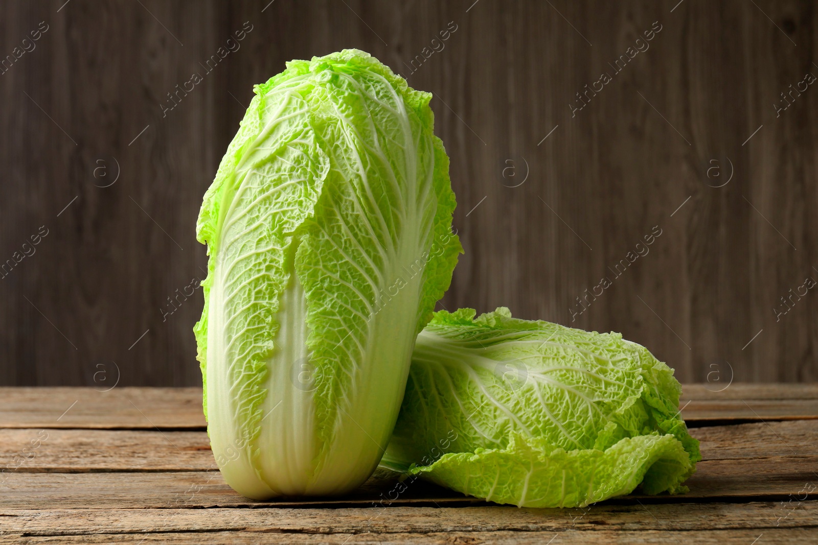 Photo of Fresh ripe Chinese cabbages on wooden table