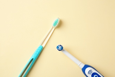 Photo of Manual and electric toothbrushes on color background. Dental care