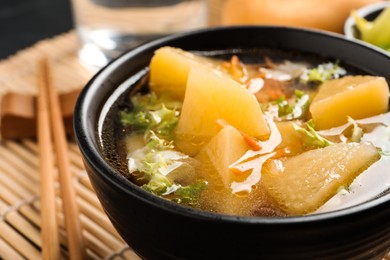 Photo of Bowl of tasty turnip soup served on table, closeup