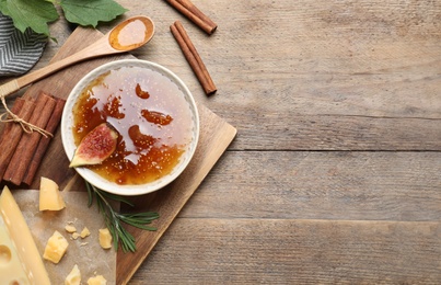 Photo of Flat lay composition with delicious fig jam on wooden table. space for text