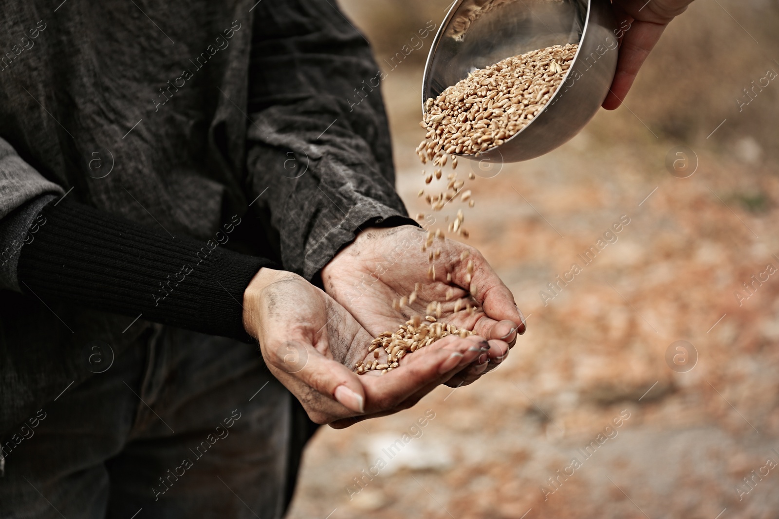 Photo of Woman giving poor homeless person bowl of wheat outdoors, closeup