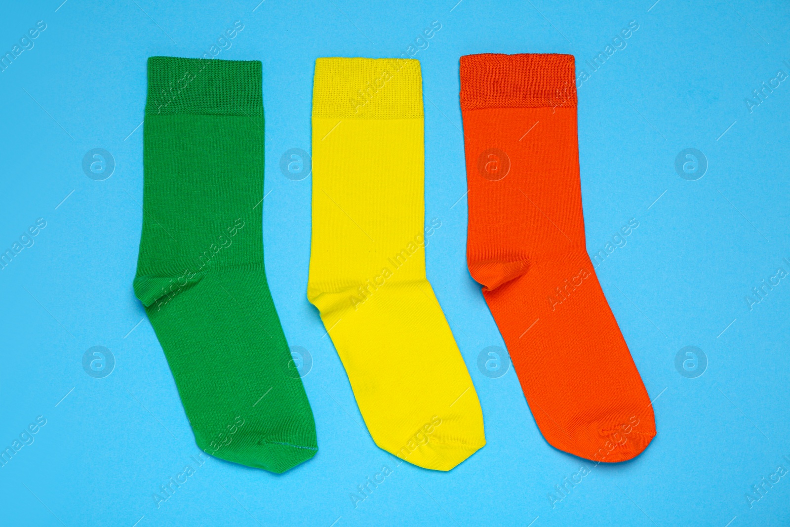 Photo of Different socks on light blue background, flat lay