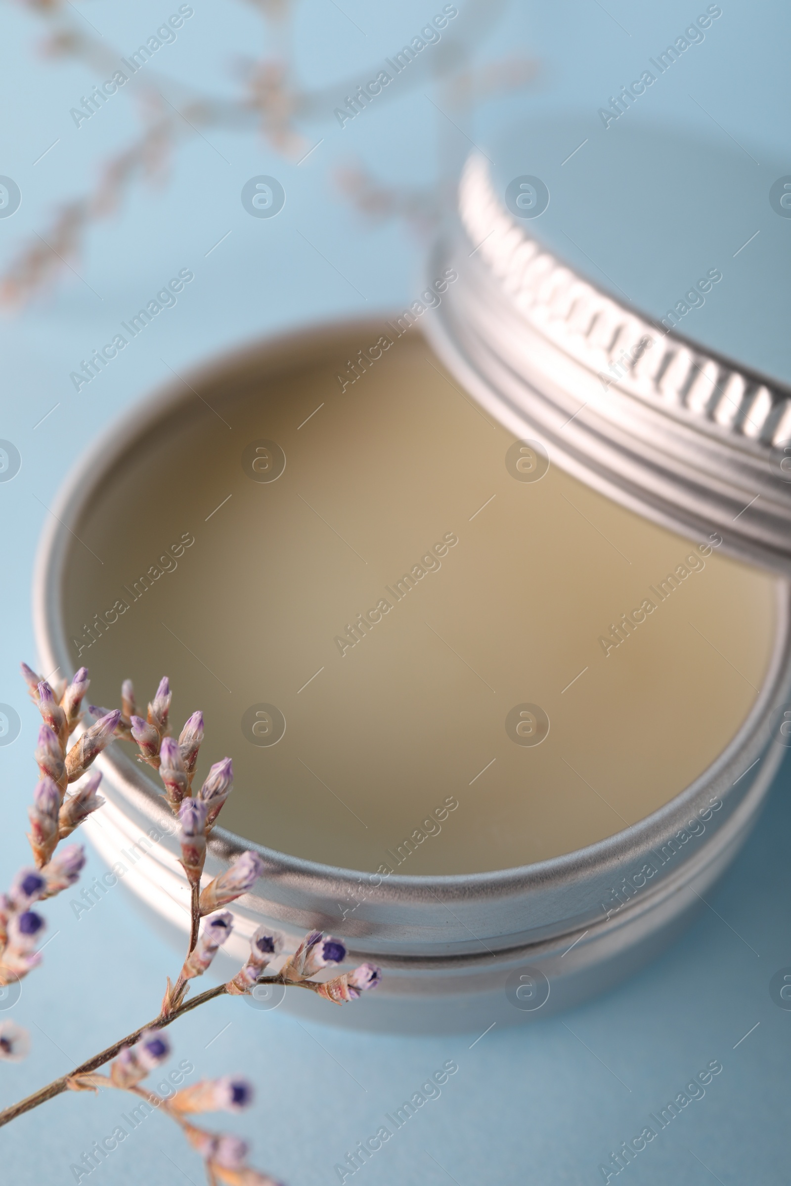 Photo of Lip balm on light blue background, closeup