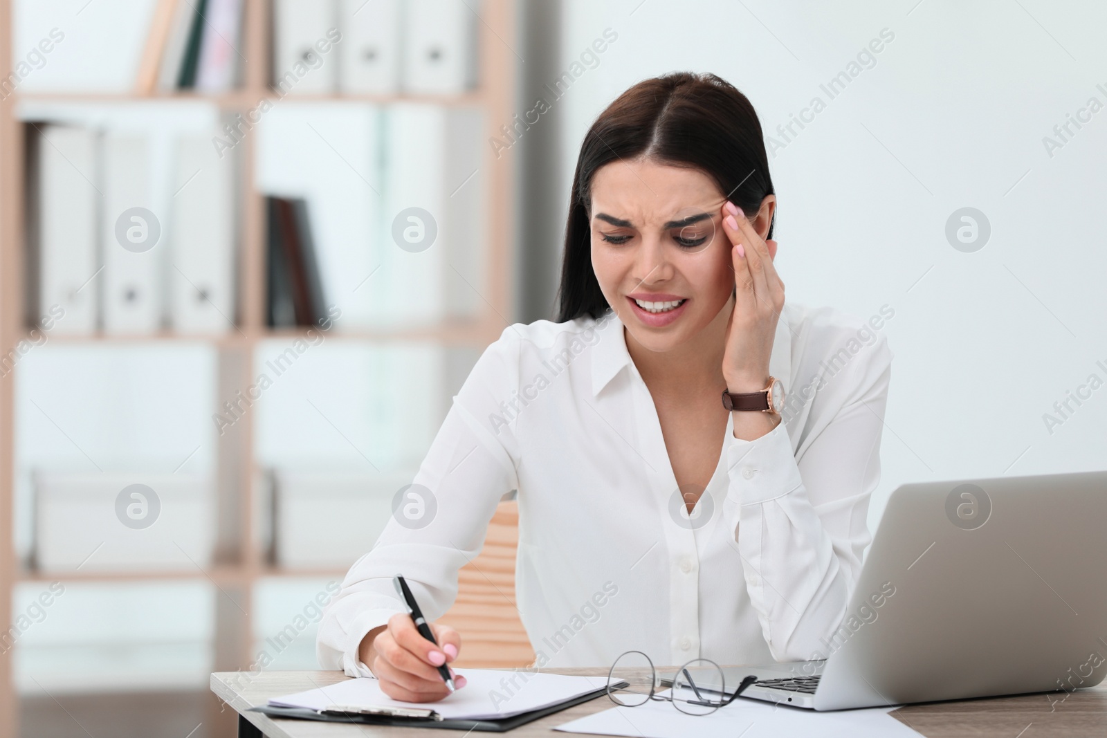 Photo of Woman suffering from migraine at workplace in office, space for text