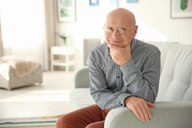 Elderly man sitting on couch in living room