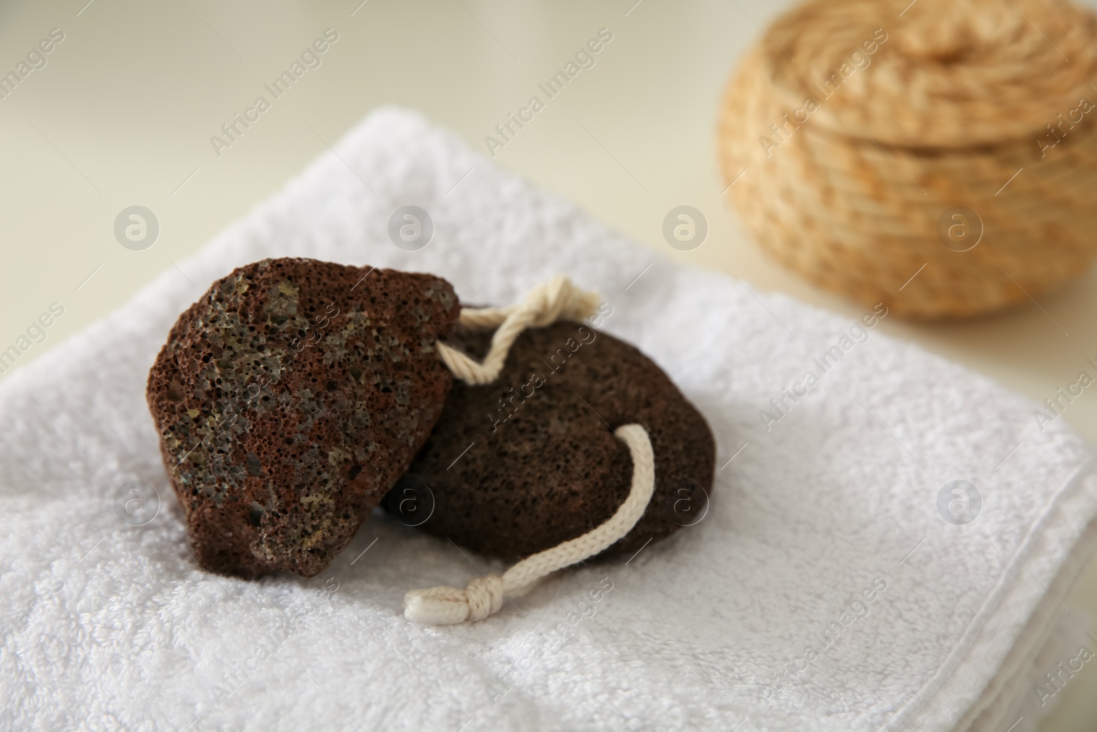 Photo of Pumice stones with folded towel on countertop in bathroom, closeup