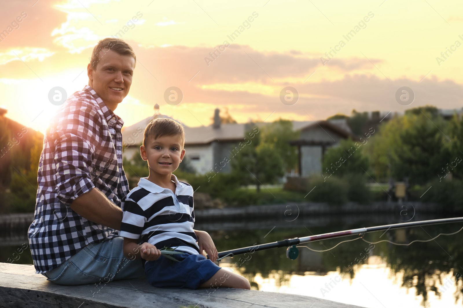 Photo of Dad and son fishing together on sunny day