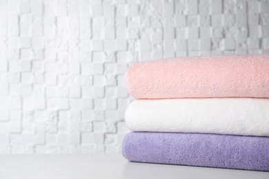 Photo of Stack of soft bath towels on table. Space for text