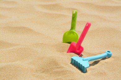 Photo of Set of colorful beach toys on sand, space for text