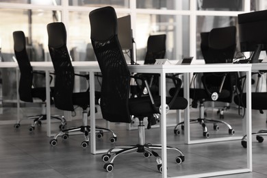 Photo of Comfortable office chairs and tables in meeting room