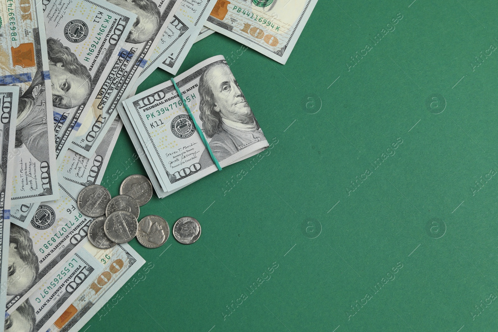 Photo of Money exchange. Dollar banknotes and coins on green background, flat lay. Space for text