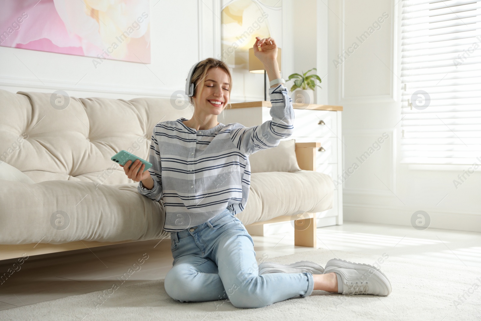 Photo of Young woman listening to music at home