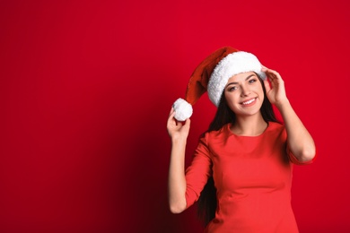 Photo of Young beautiful woman in Santa hat on color background. Christmas celebration