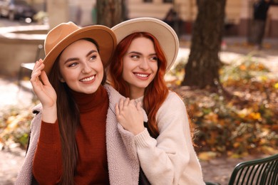 Happy friends spending time together outdoors on autumn day