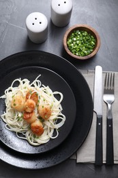 Photo of Delicious scallop pasta with green onion served on grey table, flat lay