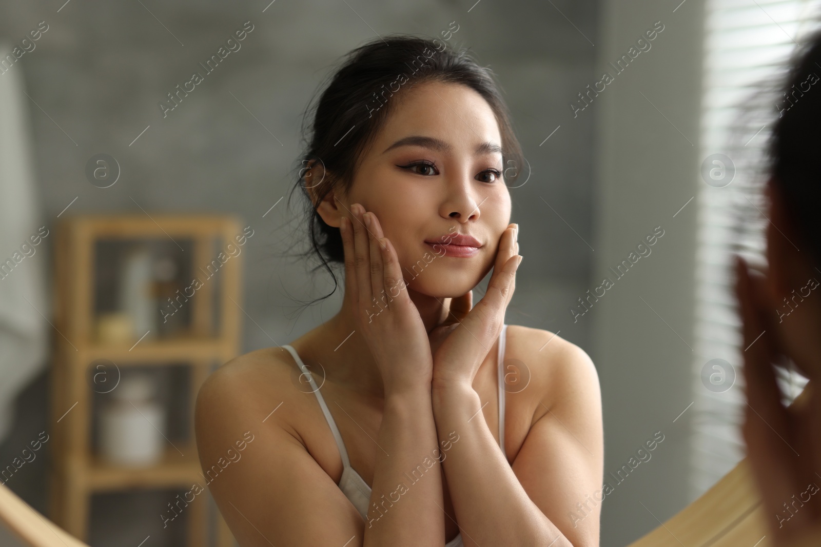 Photo of Portrait of beautiful woman near mirror indoors