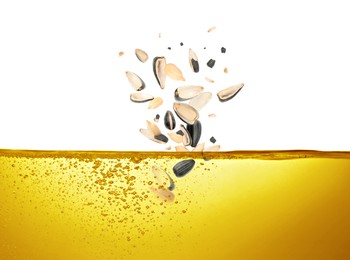 Sunflower seeds falling into cooking oil on white background