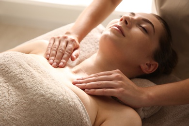 Photo of Young woman receiving body massage in spa salon