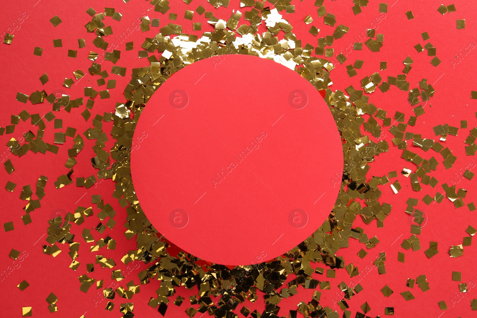 Photo of Frame of shiny golden confetti on red background, flat lay. Space for text