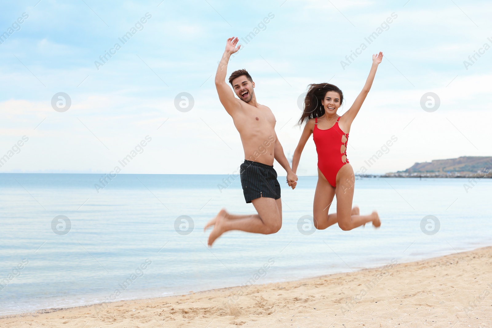 Photo of Happy young couple having fun together on beach near sea