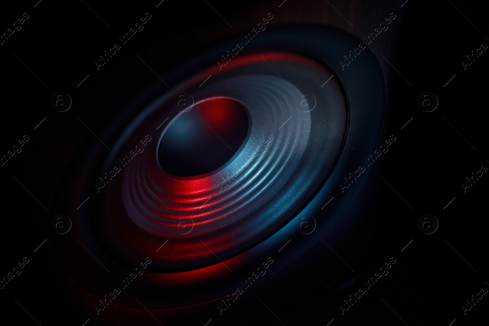 Photo of One sound speaker in neon light on black background, closeup