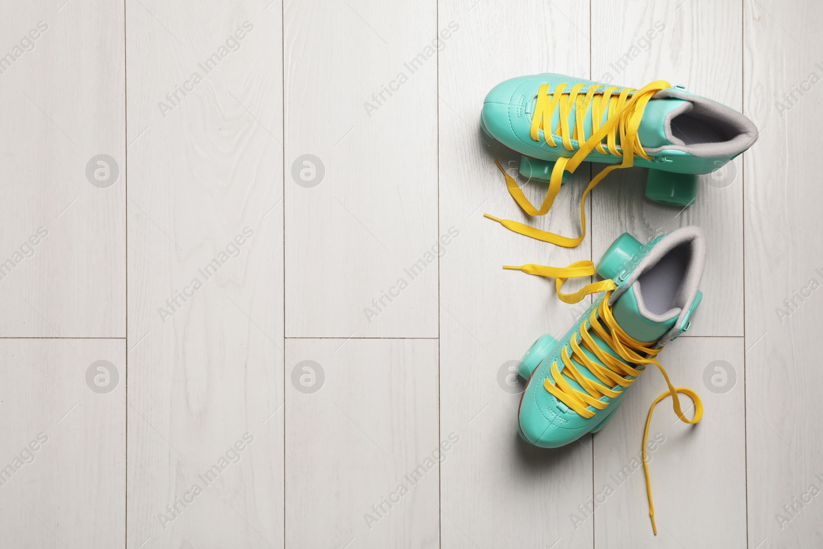 Photo of Pair of stylish quad roller skates on wooden background, top view with space for text