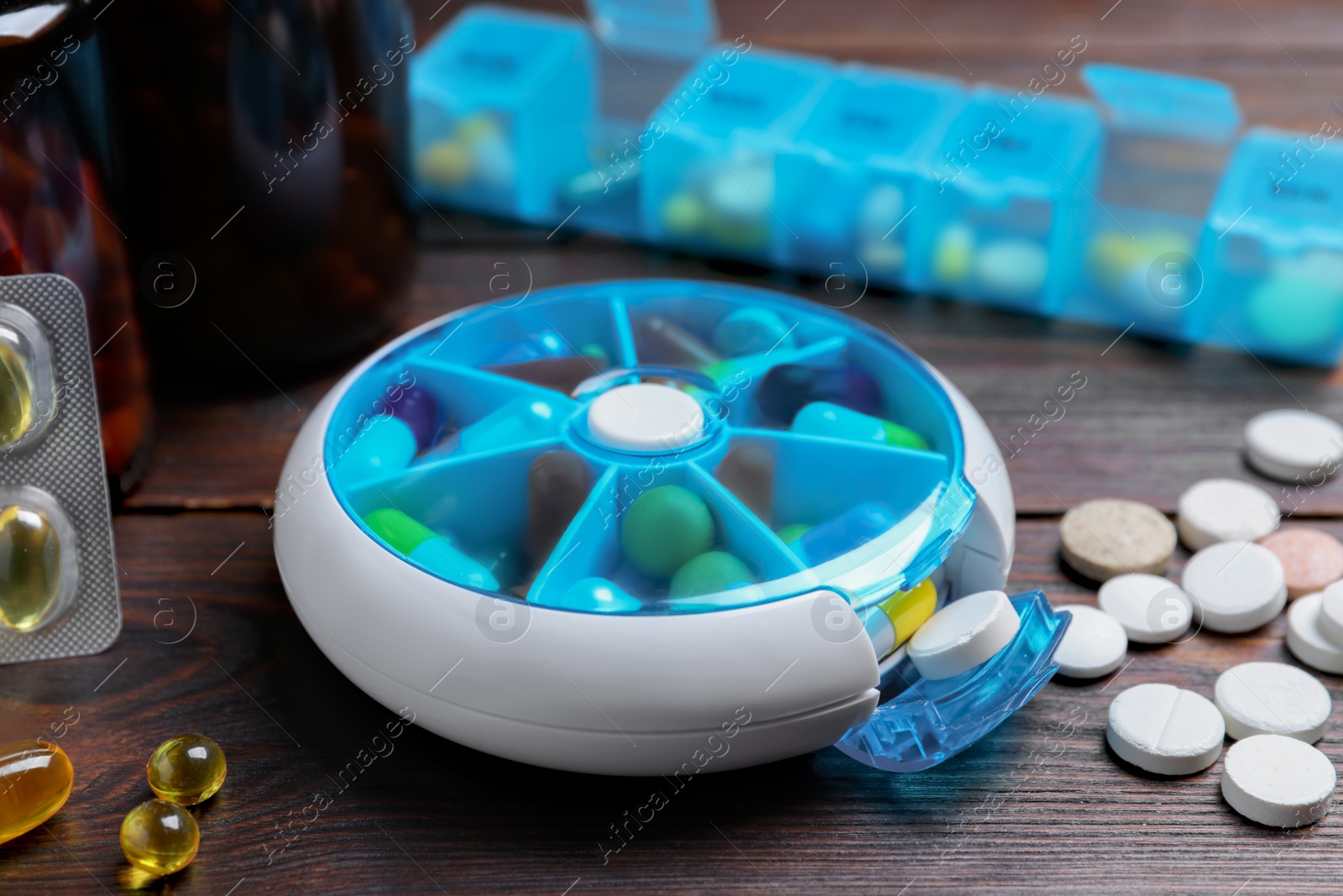 Photo of Pill boxes with medicaments on wooden table, closeup