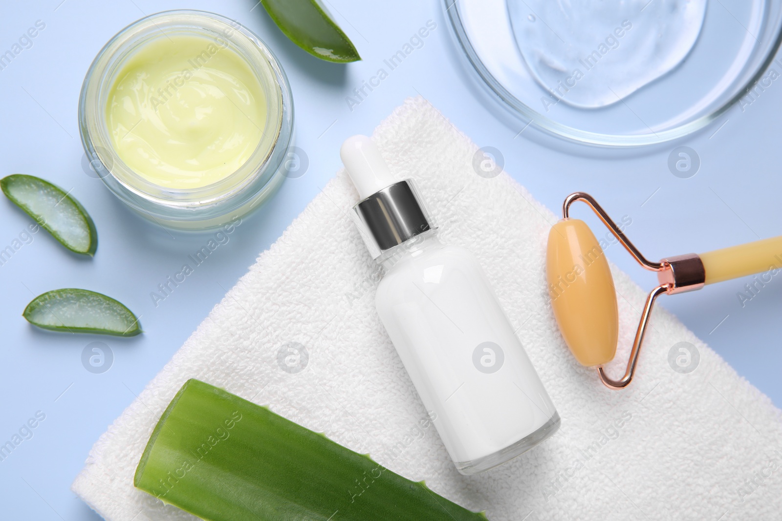 Photo of Flat lay composition with cosmetic products and cut aloe leaves on light blue background