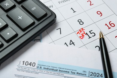 Photo of Calendar with date reminder about tax day, documents, pen and calculator, closeup