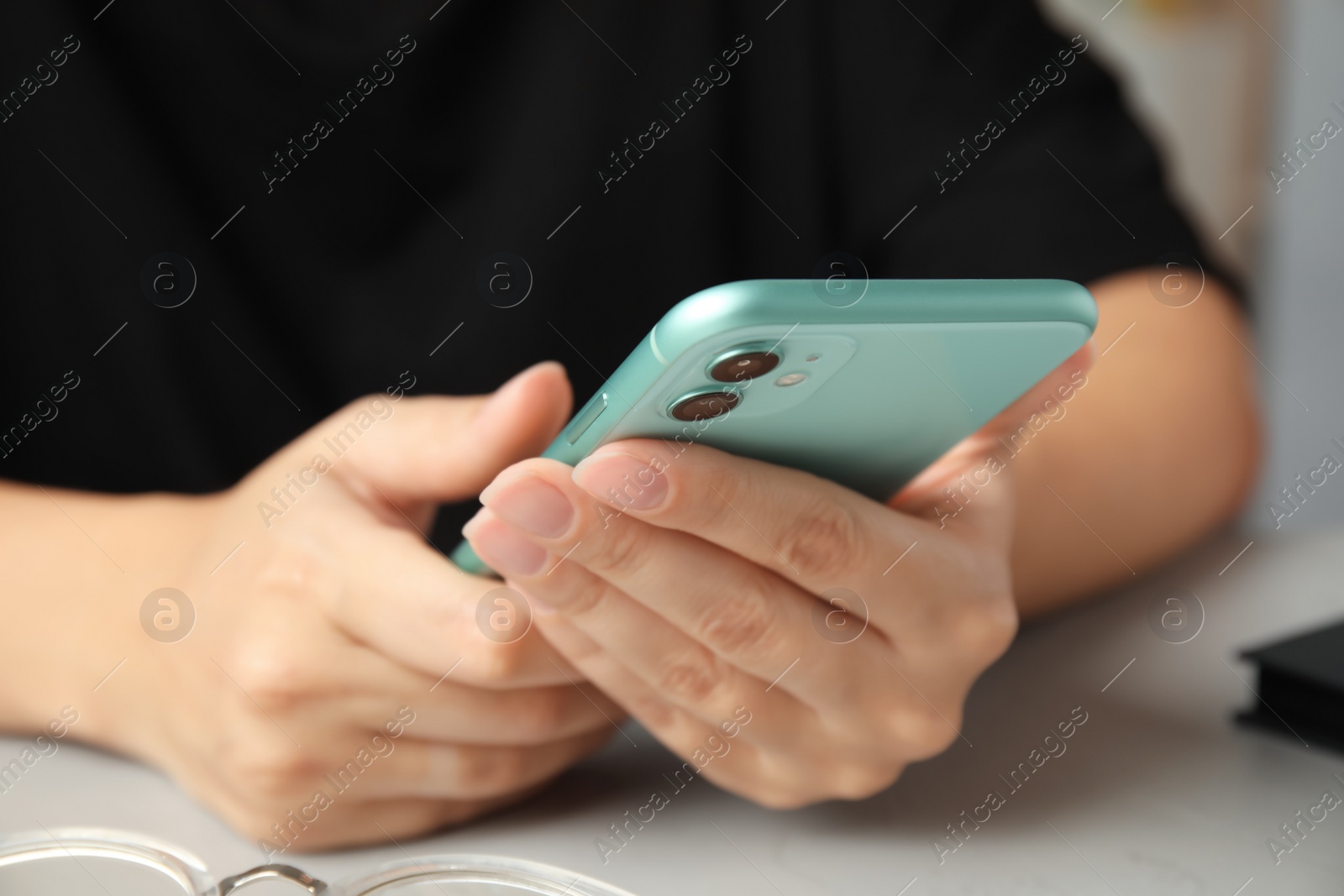 Photo of MYKOLAIV, UKRAINE - JULY 9, 2020: Woman holding Iphone 11 Green at table, closeup