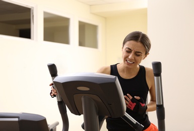 Photo of Young woman having heart attack on treadmill in gym