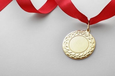 Gold medal on white background, space for text. Symbol of victory