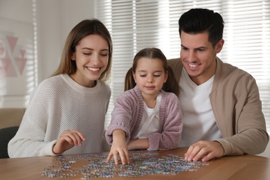 Happy family playing with puzzles at home