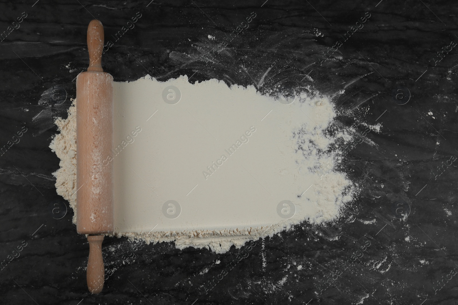 Photo of Flour and rolling pin on grey marble table, flat lay with space for text
