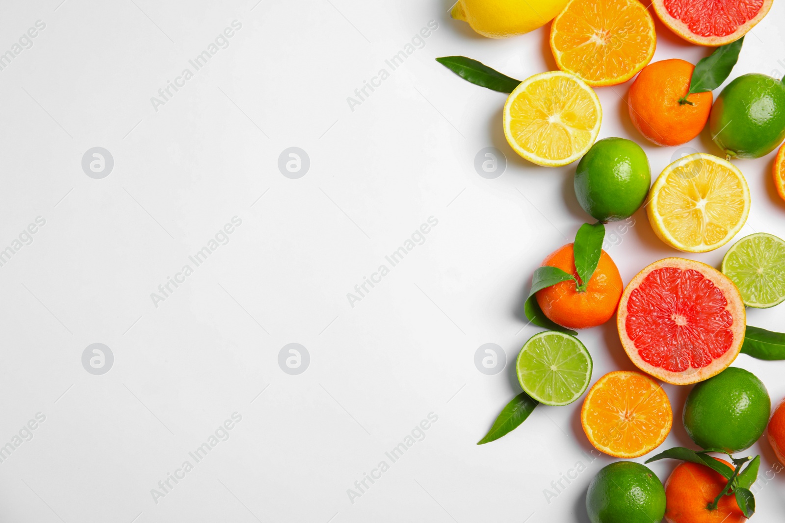 Photo of Different citrus fruits on white background, top view. Space for text