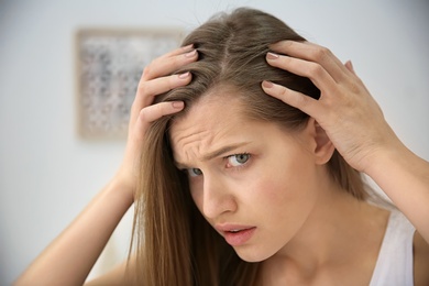 Photo of Young woman with hair loss problem indoors