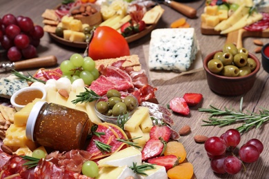 Photo of Many different appetizers served on wooden table