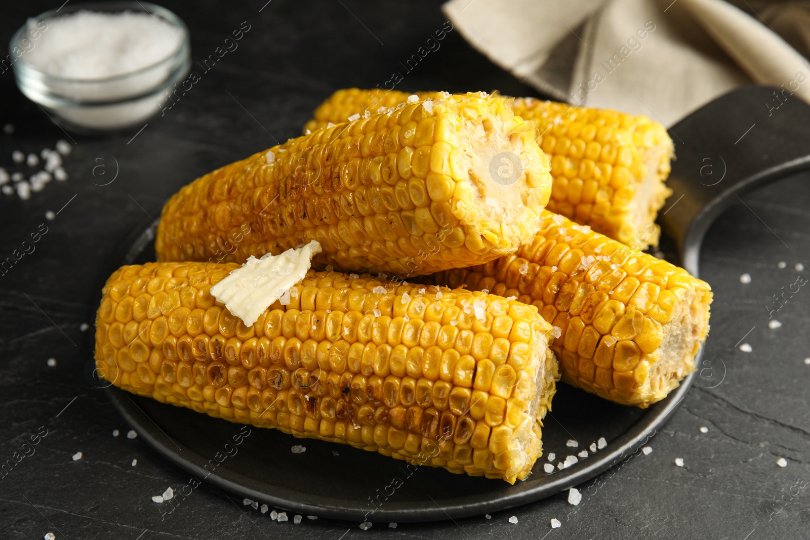 Photo of Delicious grilled corn with butter on table