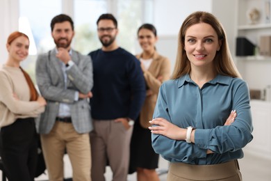 Photo of Portrait of happy businesswoman and her team in office