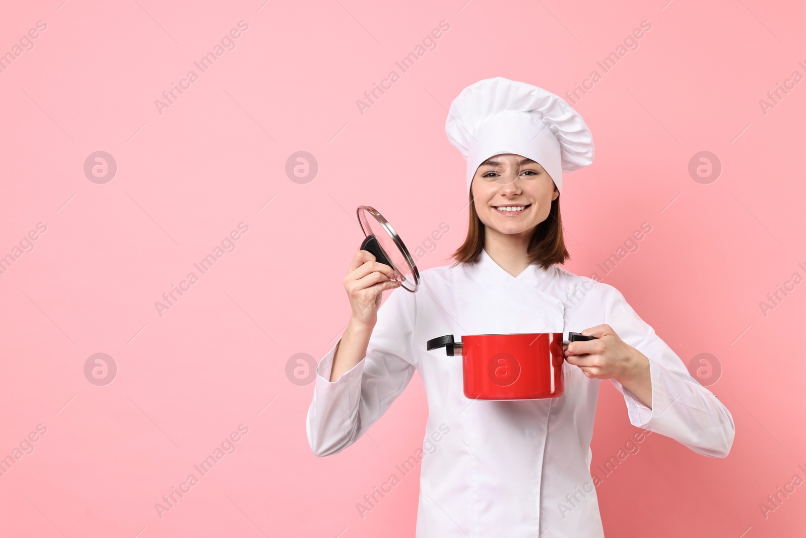 Photo of Professional chef with cooking pot on pink background. Space for text
