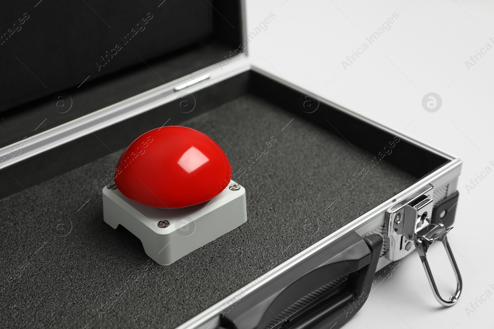 Photo of Red button of nuclear weapon in suitcase on white background. War concept