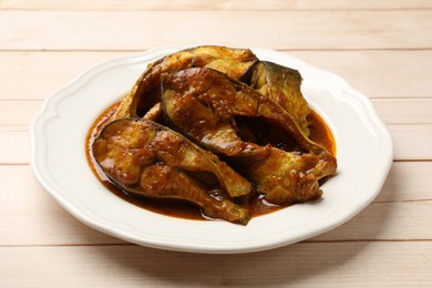 Photo of Tasty fish curry on white wooden table, closeup. Indian cuisine