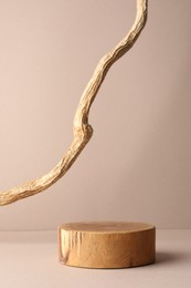 Photo of Presentation for product. Wooden podium and tree branch on beige background