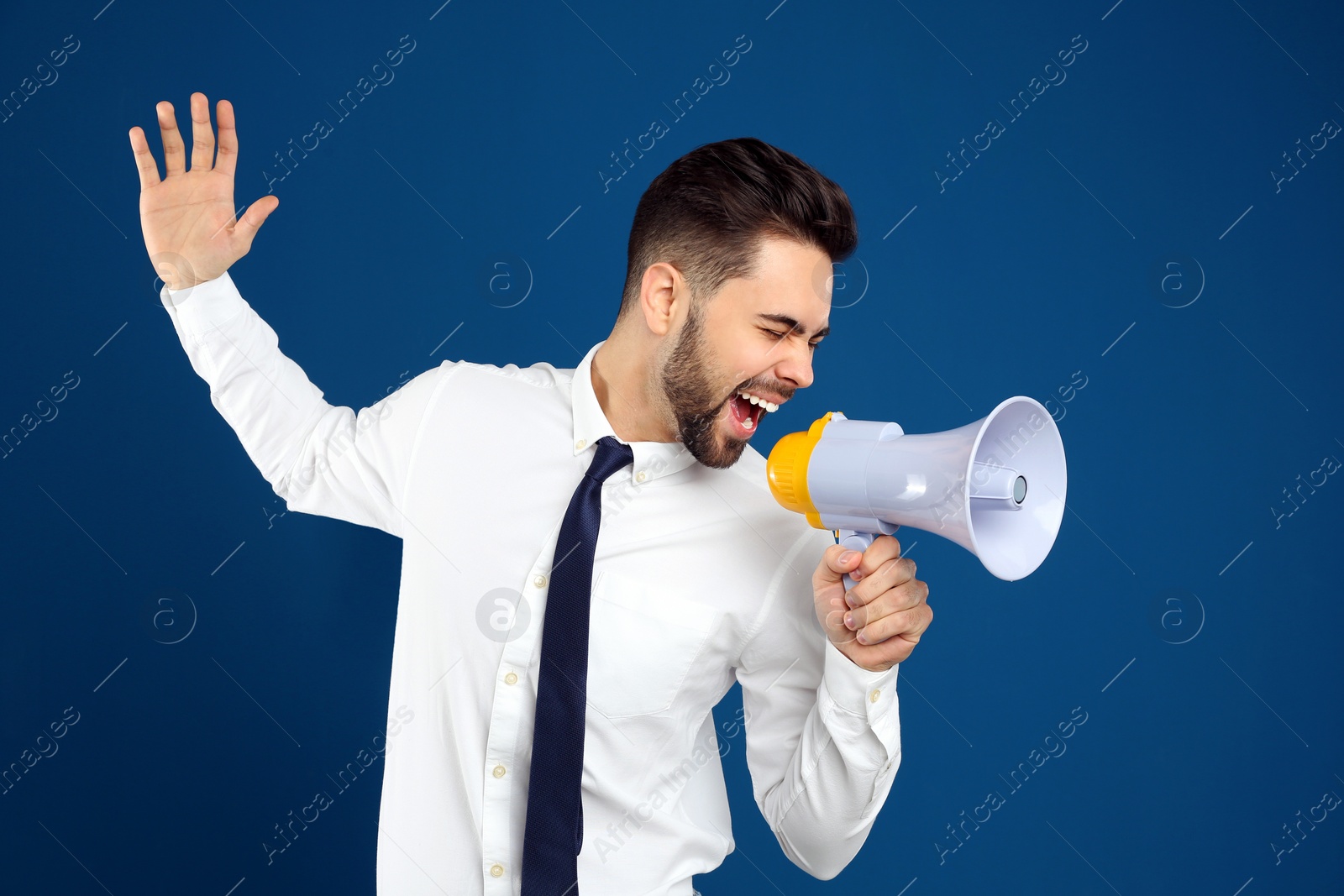 Photo of Young man with megaphone on blue background