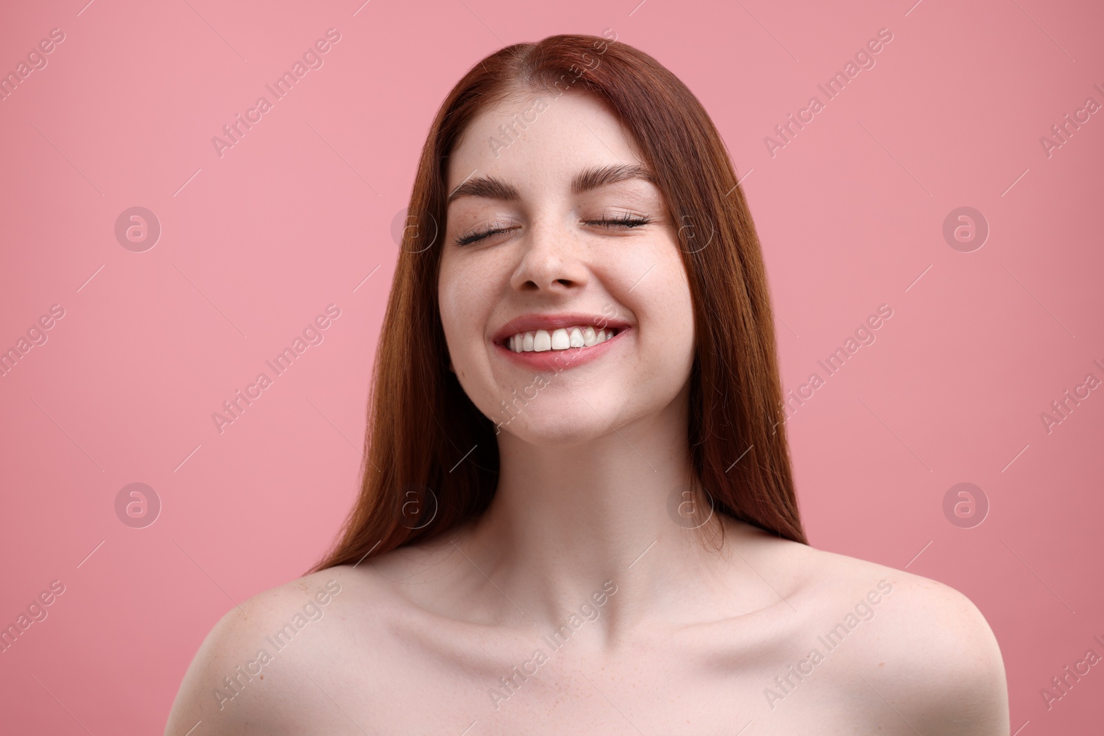 Photo of Portrait of smiling woman with freckles on pink background