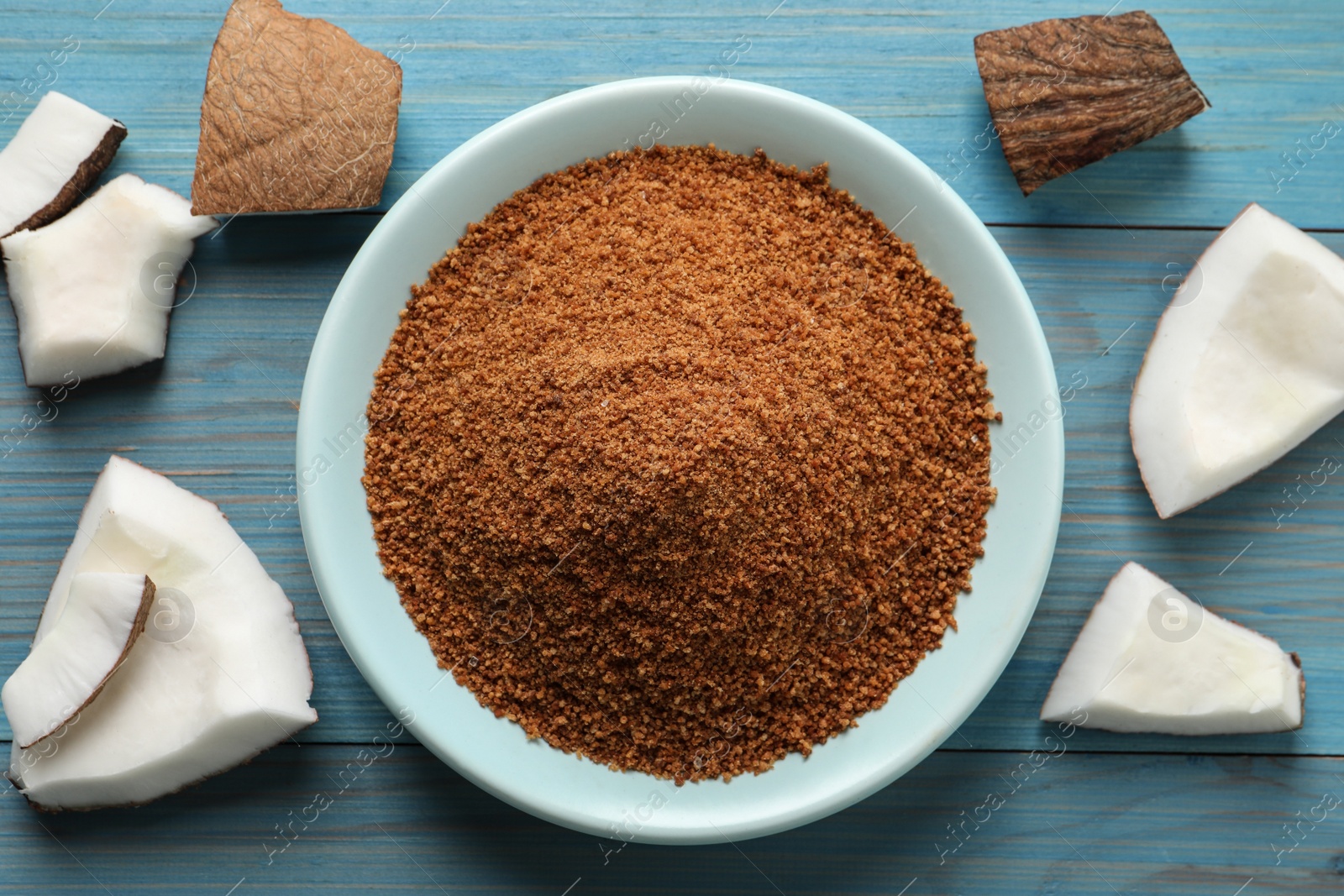 Photo of Flat lay composition with natural coconut sugar on blue wooden table