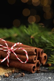 Photo of Different aromatic spices and fir branches on grey textured table, closeup